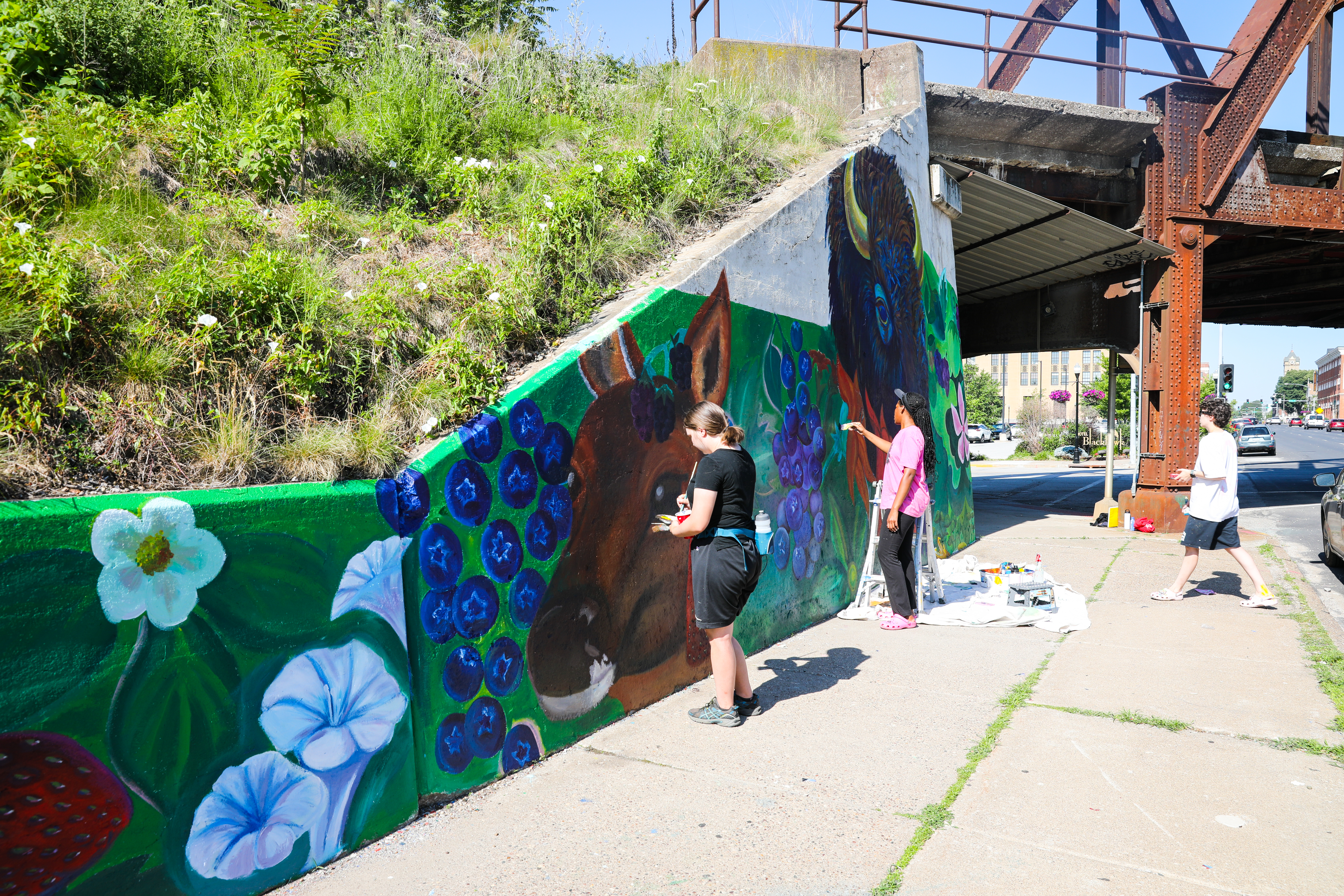 Metro Arts student apprentice painting mural in Davenport