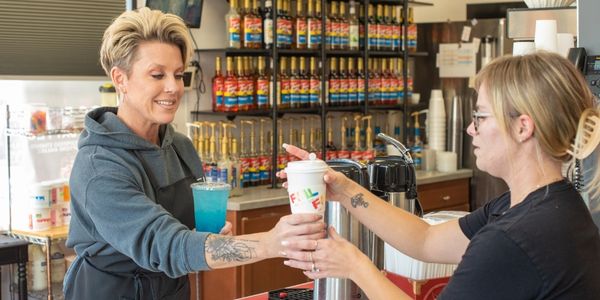 photo of woman being handed a drink at QC Fuel