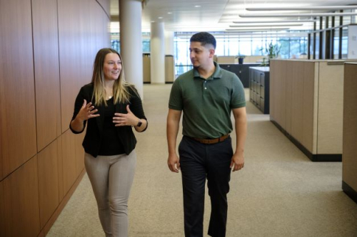 Two Modern Woodmen employees talking as they walk a hall