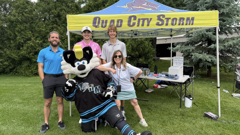 People posing for a photo with a mascot